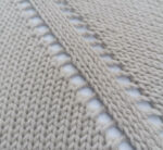 Detailaufnahme einer Raglanline mit drei Raglanmaschen und Umschlägen (Lochmuster).