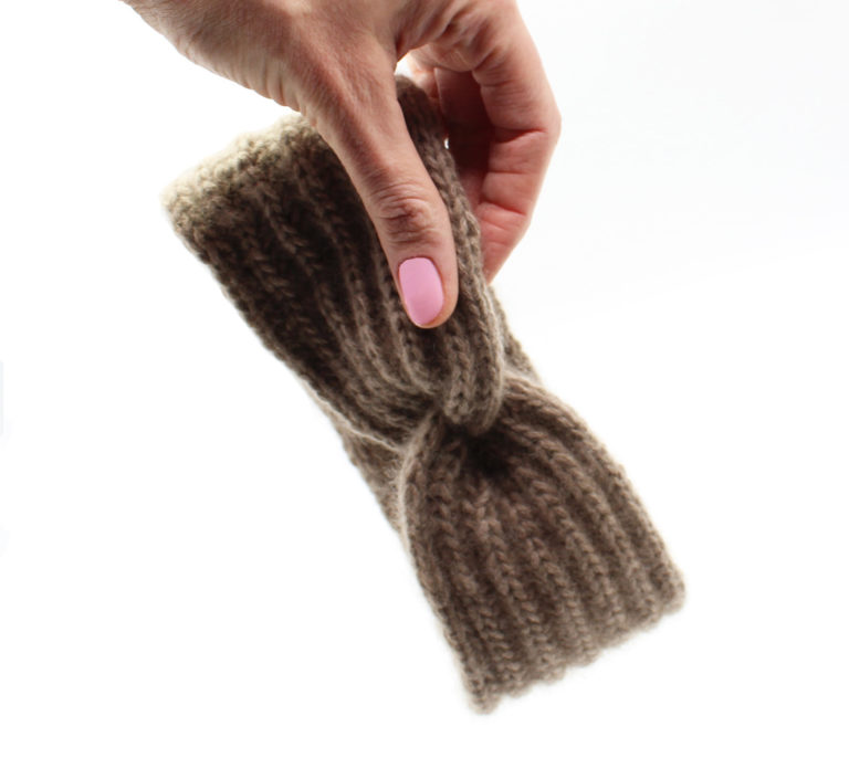 Selbstgestricktes Stirnband mit einem Twist im Patentmuster. Das Bild zeigt das fertige Modell der kostenlosen Strickanleitung zum Thema Stirnband mit Twist stricken.